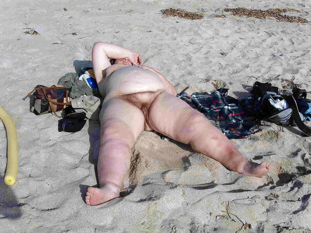 Голая секс бомба на пляже в песке